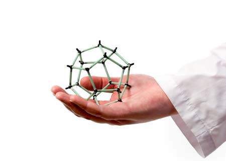 Scientist's hand holding molecular model of graphite sphere