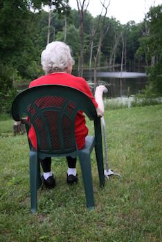 Older woman sitting looking at a stream